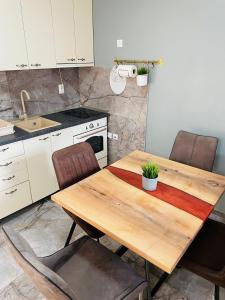 una cucina con tavolo e sedie in legno di Muki apartments a Surčin