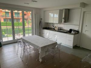 cocina con mesa y sillas en una habitación en Arianna Golf - Appartamento con camino e sauna golf club Margara en Fubine