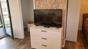 einen Fernseher auf einer Kommode in einem Schlafzimmer in der Unterkunft PEMATRA Ferienwohnung Strandmuschel in Travemünde