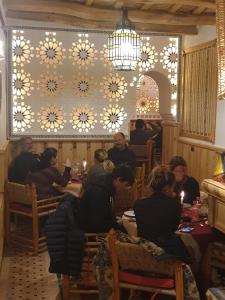 un gruppo di persone seduti a un tavolo in un ristorante di Dar Jnan Tiouira Dades a Tamellalt