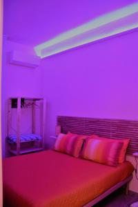 een paarse slaapkamer met een bed met roze verlichting bij La Lanterna di Franca e Cassio in Pisa