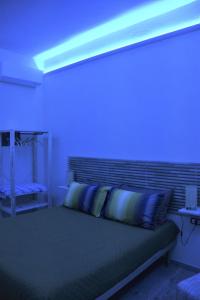 een slaapkamer met een bed met een blauw licht erop bij La Lanterna di Franca e Cassio in Pisa