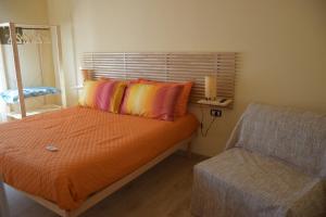 een slaapkamer met een bed met oranje lakens en oranje kussens bij La Lanterna di Franca e Cassio in Pisa