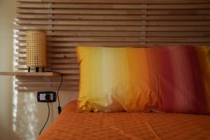een slaapkamer met een bed met een kleurrijke deken erop bij La Lanterna di Franca e Cassio in Pisa