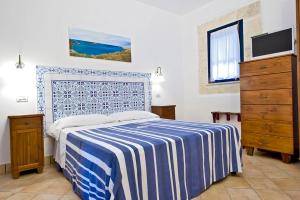 Miramare Residence في فافينانا: غرفة نوم بسرير وبطانية زرقاء وبيضاء