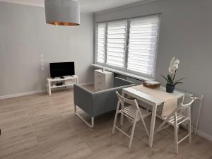 sala de estar con mesa, sillas y TV en APARTAMENT OŚ. ZŁOTE 5F en Dzierżoniów