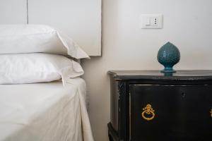 Un dormitorio con una cama y una mesa con un jarrón. en Masseria Spartivento en Conca Specchiulla