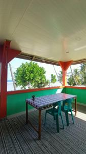 une table et deux chaises dans une pièce dans l'établissement Aloha Guest House Nias, à Hilibotodane