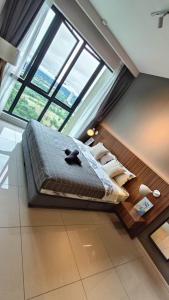 ein großes Bett in einem Zimmer mit einem großen Fenster in der Unterkunft B Home in Nusajaya
