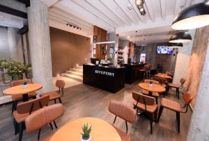 a restaurant with wooden tables and chairs and a counter at Alexandar Square Boutique Hotel in Skopje