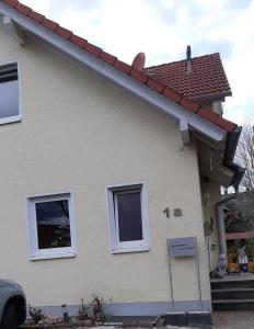 een huis met twee ramen en een rood dak bij Appartement am Rondell in Hösbach