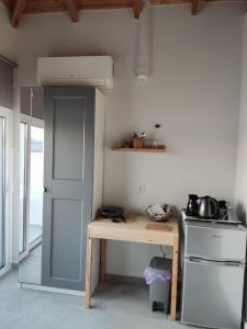 a small kitchen with a table and a stove at Theros - Bahia in Elafonisos