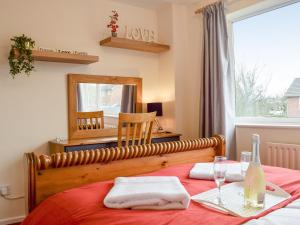 a bedroom with a bed with a red blanket and a mirror at Baileys Tavern in Wartnaby