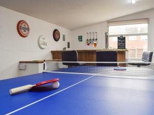 una mesa de ping pong con un bate. en Baileys Tavern en Wartnaby
