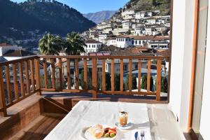 a table with a plate of food on a balcony at Hotel Rezidenca Desaret in Berat