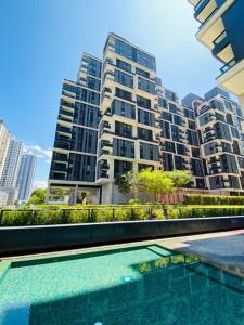 吉隆坡的住宿－Arcoris Soho 2bedroom 1-7pax Industrial Loft Style，一座大建筑前的游泳池