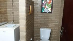 a bathroom with a white toilet and a sink at Hotel Fazenda Terra Ramos in Papucaia