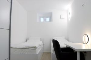 1 dormitorio con cama, escritorio y silla en Lumi - modern apartment with parking, en Maribor
