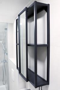 un armario de cristal negro en el baño con ducha en Lumi - modern apartment with parking, en Maribor