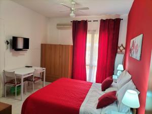 a red bedroom with a red bed and a table at Casa Vacanza Da Rosa in Letojanni