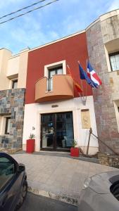 un edificio con dos banderas delante en Hotel Don Giovanni en Avola