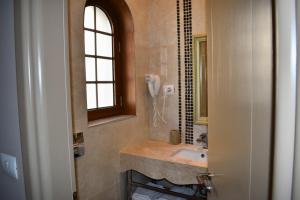 a bathroom with a sink and a phone on the wall at Hotel Rezidenca Desaret in Berat +29 photos