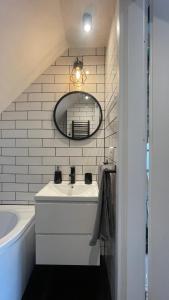 a bathroom with a sink and a mirror and a tub at Apartament Loft in Elblag