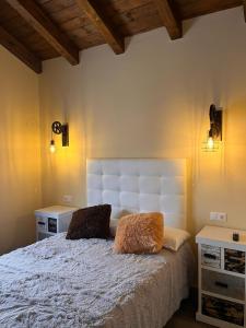 1 dormitorio con 1 cama blanca y 2 almohadas en Casas del Barranco de la Hoz en Ventosa