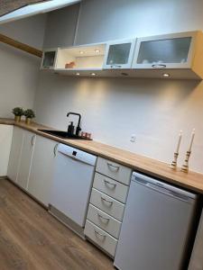 a kitchen with white cabinets and a counter top at Nybygget lækker lejlighed. in Kolding