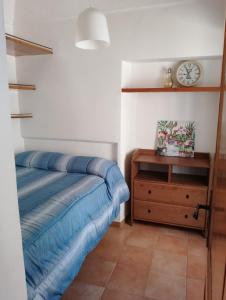 una camera con letto, cassettiera e orologio di Alloggio Turistico Lidia a Fiuggi