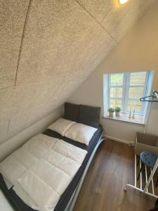 een kleine slaapkamer met een bed en een raam bij Nybygget lækker lejlighed. in Kolding