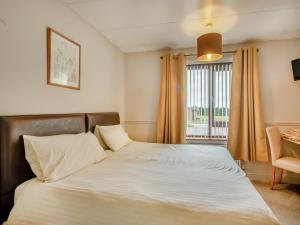 a bedroom with a large bed with a window at Barn Owl in Horsford