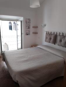 een slaapkamer met een groot wit bed en een raam bij Alloggio Turistico Lidia in Fiuggi