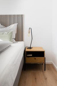 a bed with a night stand with a lamp on it at our farm Ferienwohnung in Grasberg