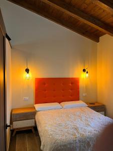 a bedroom with a large bed with an orange headboard at Casas del Barranco de la Hoz in Ventosa