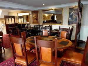 a dining room with a wooden table and chairs at Rose Tor Hotel in Llandudno