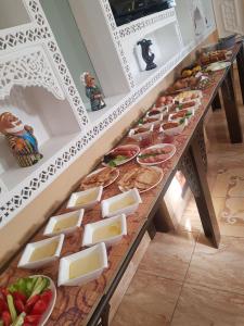 a long table with cheese and other foods on it at Sarbon Plaza Hotel in Bukhara