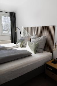 uma cama com almofadas brancas e uma janela em our farm Ferienwohnung em Grasberg