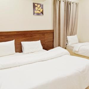 two beds in a room with white sheets at فندق الساعي Alsai Hotel in Al ‘Utaybīyah