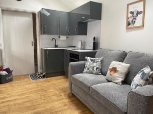 a living room with a couch and a kitchen at The Old Dairy in Hickling