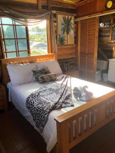 a bedroom with a bed with a leopard print blanket at Tree House Luxe in Saint Annʼs Bay