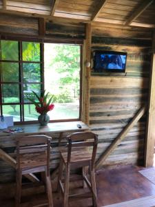 a dining room in a log cabin with a table and chairs at Tree House Luxe in Saint Annʼs Bay