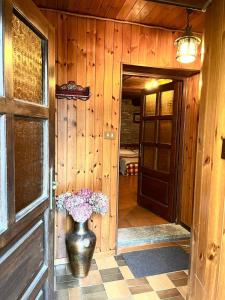 a wooden hallway with a vase with flowers in it at Monolocale rustico di montagna in Antey-Saint-André