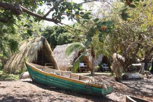 a boat sitting on the ground in front of a hut at La Sirenita - Ometepe in Altagracia