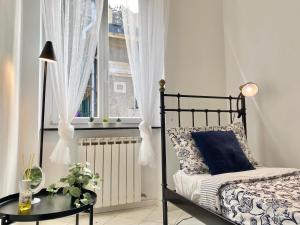 1 dormitorio con cama, mesa y ventana en TERMINAL Apartment, en Génova