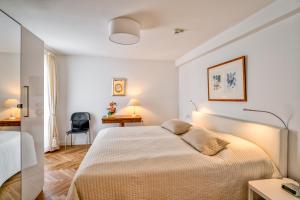 a white bedroom with a bed and a desk at Huize Mare in Bergen aan Zee