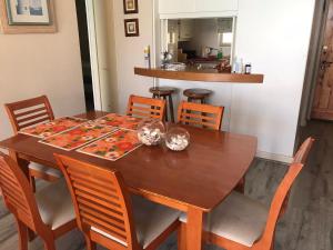 uma mesa de jantar com cadeiras e uma mesa de madeira em San alfonso timonel em Algarrobo