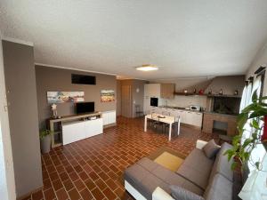 een woonkamer met een bank en een keuken bij Maison Younesco - Villa indipendente exclusive in Castagnole Lanze