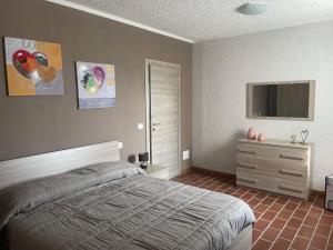 een slaapkamer met een bed, een dressoir en een televisie bij Maison Younesco - Villa indipendente exclusive in Castagnole Lanze