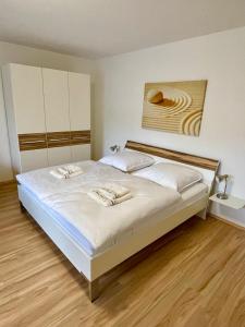 a bedroom with a large bed with white sheets at Ferienwohnung David im Haus Waldblick - Bad Bergzabern in Bad Bergzabern